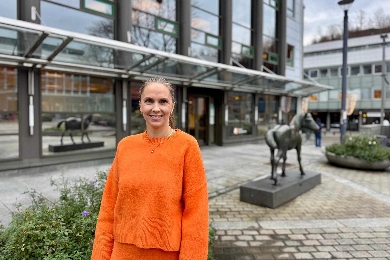 Dame står utenfor bankbygg på Nesttun