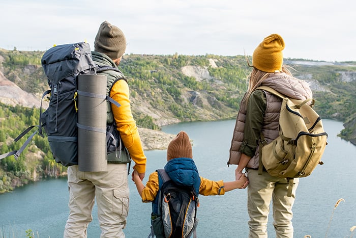 mor og far holder barn i handen og ser pa utsikt i naturen mor og far holder barn i handen og ser pa utsikt i naturen